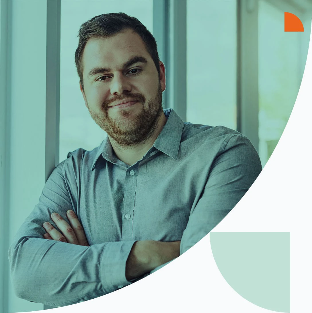 Mann im mittleren Alter lehnt am Fenster und schaut in die Kamera